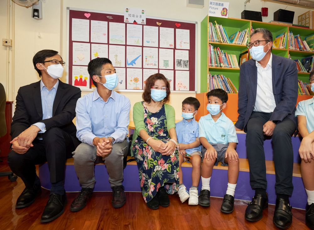 The SDEV, Mr Michael WONG (first from the right), is chatting with students and parents. The first from the left is the C for H, Mr Ivanhoe CHANG.