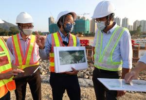 The SDEV, Mr Michael WONG (right), is briefed by the Chief Engineer of the North Development Office of the CEDD, Mr Mike CHO (centre), on the progress of the site formation and infrastructure works in Fanling North Area 15 East for public housing development.