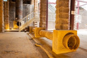 Pictured are the 12-inch-diameter outlet pipes and a half-round channel next to the pipes.