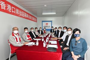 政务司司长李家超昨日（3月12日）到港珠澳大桥香港口岸人工岛，视察接收第三个由中央援建的社区隔离设施。图示李家超（右四）与中央人民政府驻香港特别行政区联络办公室副主任尹宗华（左三）和承建商中国建筑国际集团有限公司主席兼非执行董事颜建国（左二），在视察前举行交接座谈会。与会者包括食物及卫生局局长陈肇始教授（右六）、发展局局长黄伟纶（右三）、保安局局长邓炳强（右五）、发展局常任秘书长（工务）刘俊杰（右二）、建筑署署长何永贤（右一）和医院管理局行政总裁高拔陞医生（右七）。