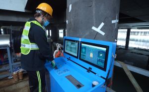Photo shows an operator remotely controlling the river desilting robot to enter a river. The silt is located by the closed-circuit television and sonar device installed on the robot and collected by suction.