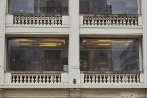 The building also has delicate design elements, such as urn-shaped balustrades and simple lines decorating the top of the columns.