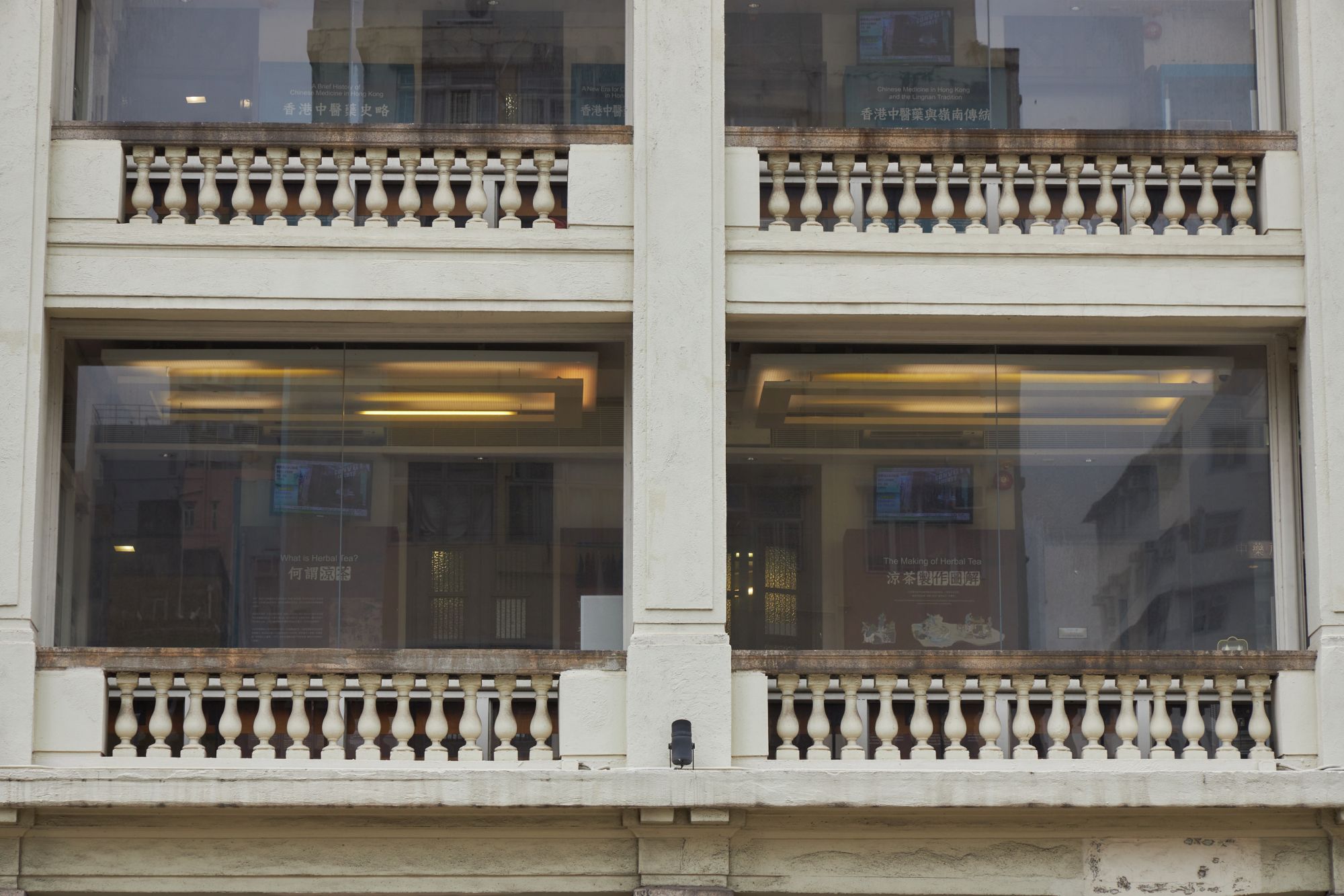 The building also has delicate design elements, such as urn-shaped balustrades and simple lines decorating the top of the columns.