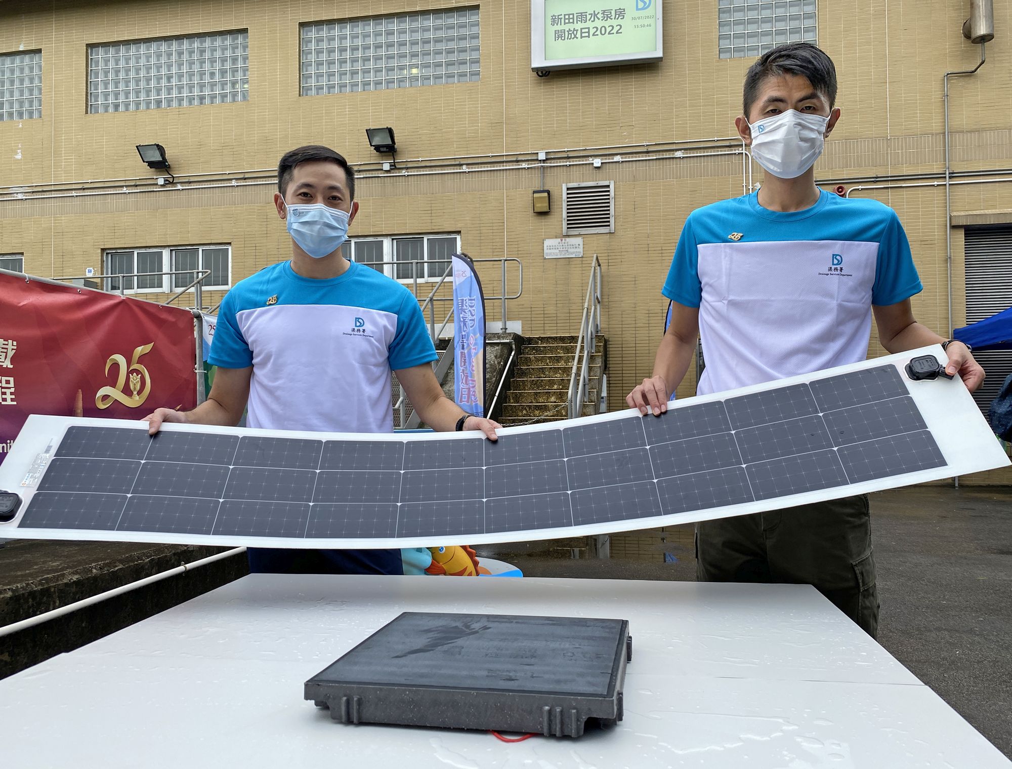 Mr LAI Hong-ho (left) and Mr CHIM Sai-shing (right) introduce the flexible PV system and the steppable PV system, which are installed respectively on the covers of the screw pump channels at the intake of the San Tin Stormwater Pumping Station, and on the walkway of the maintenance platform.