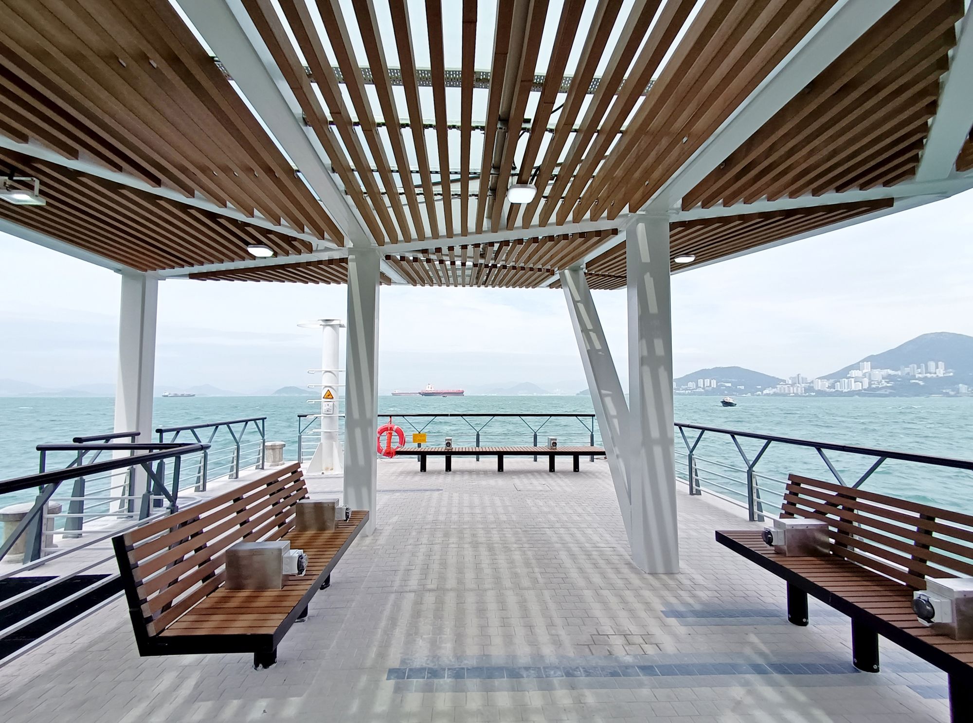 To blend in with the surrounding environment and take advantage of natural light, the roof cover of the pier is made of tempered glass and environmentally-friendly wooden trellis.