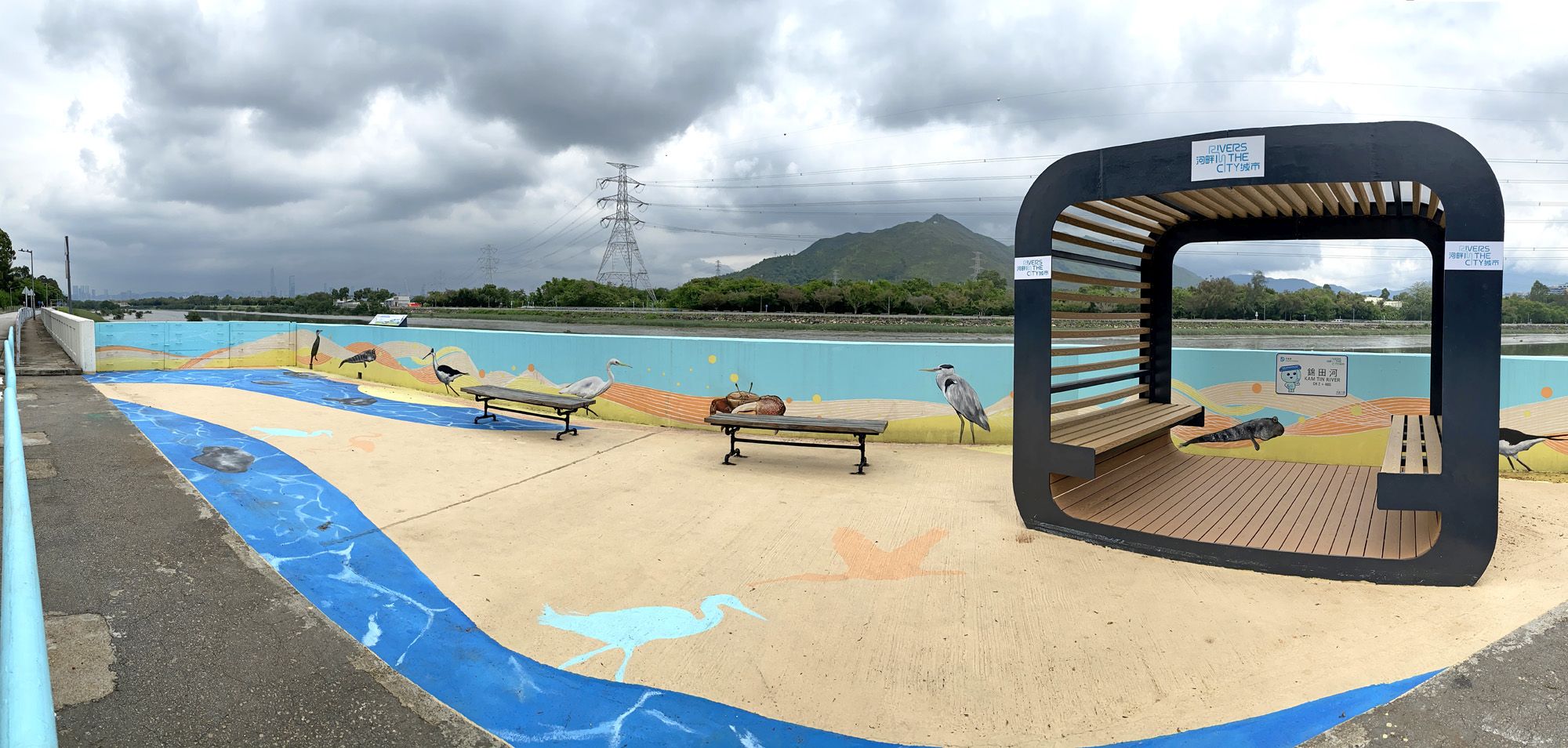 The maintenance access near the Yuen Long Bypass Floodway Engineered Wetland has been converted into a public space with murals, a pavilion, benches, etc. for public enjoyment.