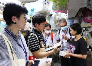 手持文件夾的水務署與差餉物業估價署同事採取跨部門聯合行動，探訪「劏房」租戶，了解他們有否被濫收水費及宣傳有關法例的要求。