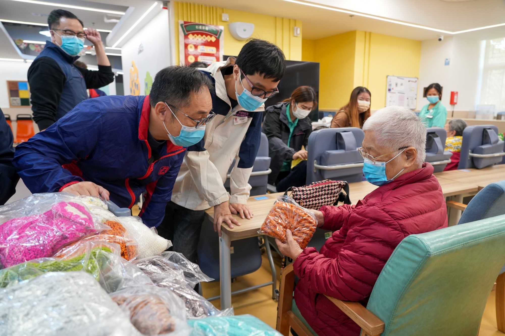 機電工程署義工隊編織百多條頸巾，親自送贈長者。