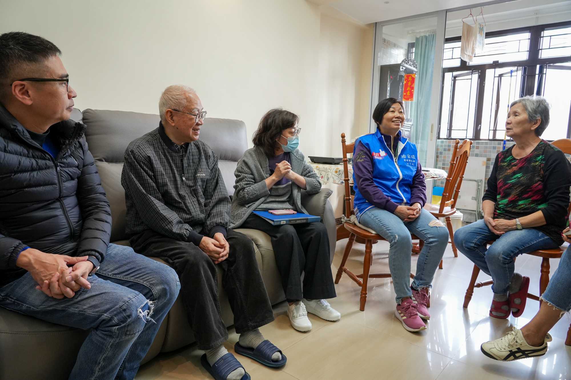 Elderly owners Mr and Mrs TANG (second left and first right), who used to live in an old building in Mong Kok, benefited from the redevelopment of the old district which took place years ago and moved to a younger building with lifts.
