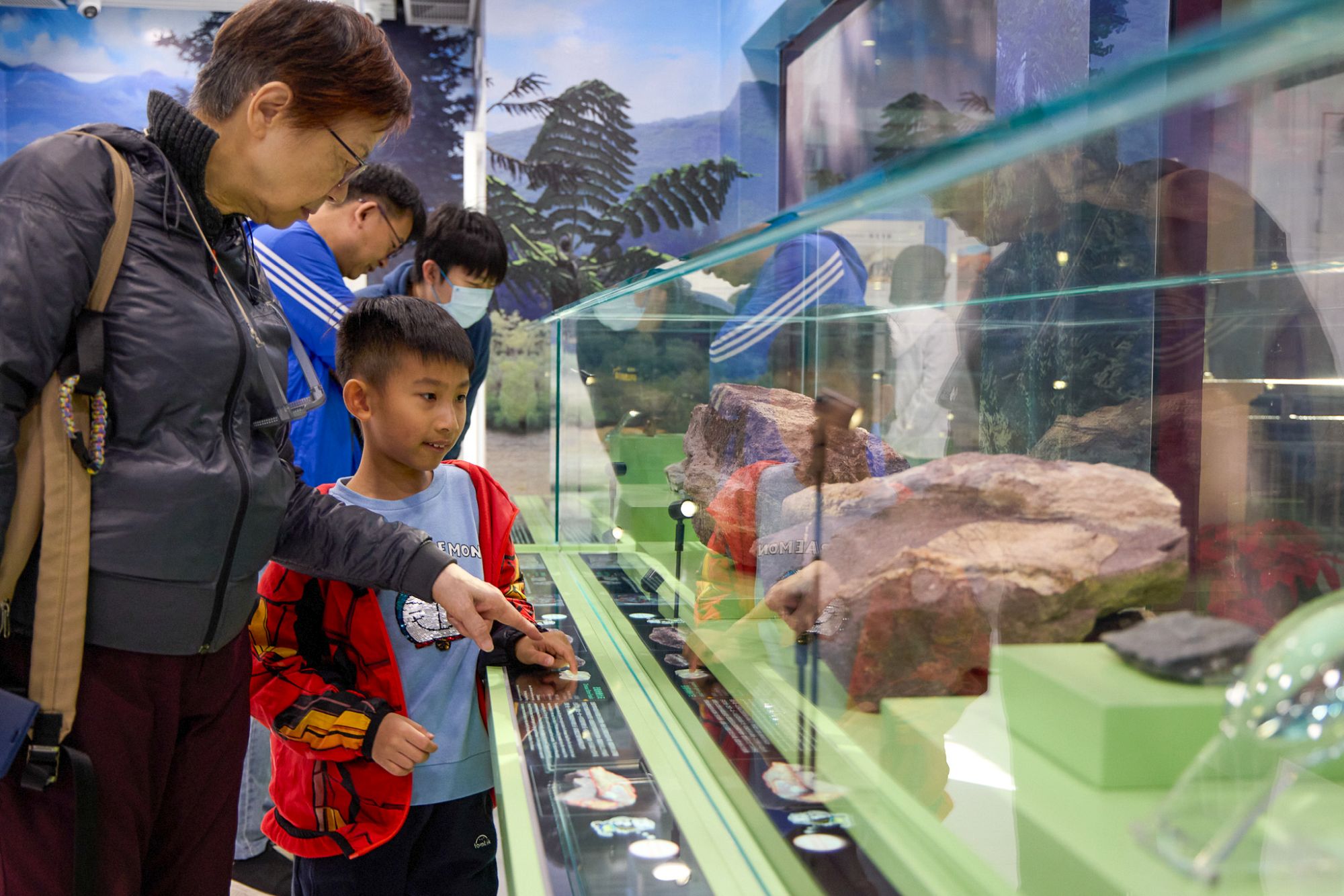 市民觀賞赤洲出土的恐龍化石（上）和學校團體觀看專家和工作人員清修恐龍化石（下）。