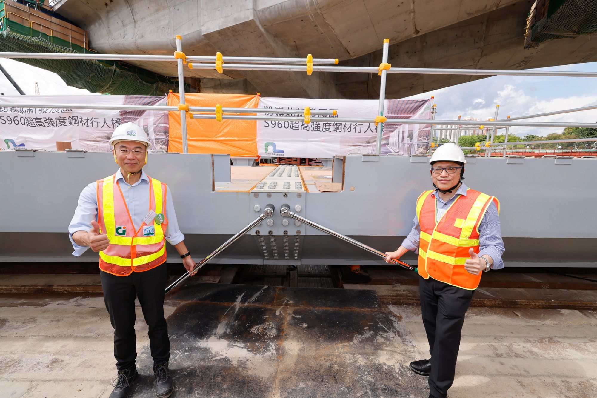 土木工程拓展署署長方學誠（左）與香港理工大學國家鋼結構工程技術研究中心（香港分中心）主任鍾國輝（右）在S960行人天橋組裝儀式中共同為行人天橋收緊連接螺栓。  