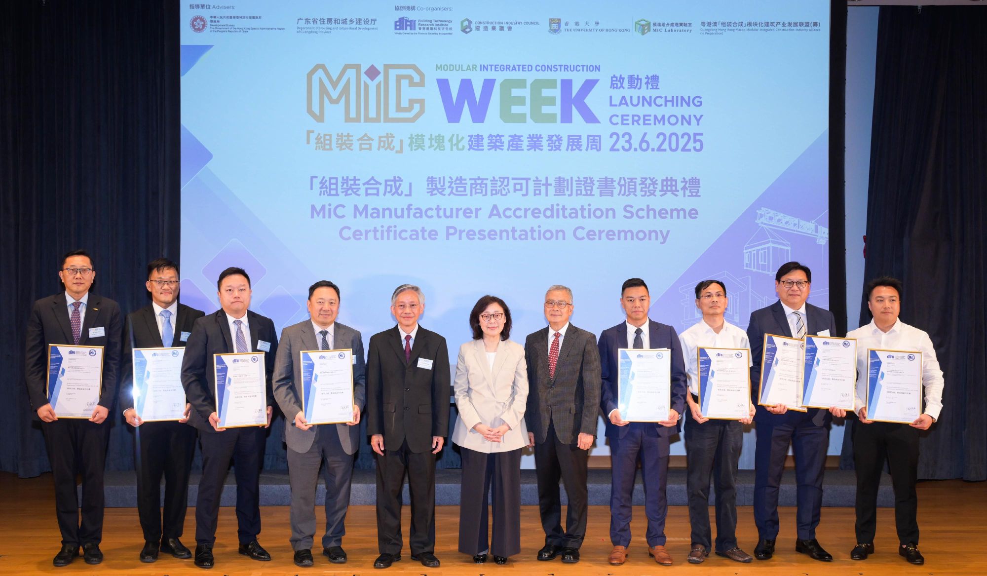 The Secretary for Development, Ms Bernadette LINN (centre); the Chairperson of the BTRi, Mr HON Chi-keung (fifth left); the Vice Chairperson of the BTRi, Dr CHAN Ka-kui (fifth right) and the first batch of eight manufacturers accredited under the MiC Manufacturer Accreditation Scheme.