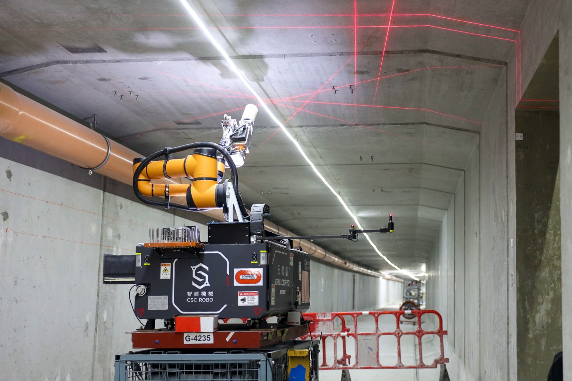 鑽孔機械人利用激光掃描技術確定好位置，並於隧道內的牆身及天花準確地鑽孔及裝上繫穩螺絲，同時會吸走過程中產生的粉塵，不僅提升工人職業安全健康水平，亦節省時間和人力成本。