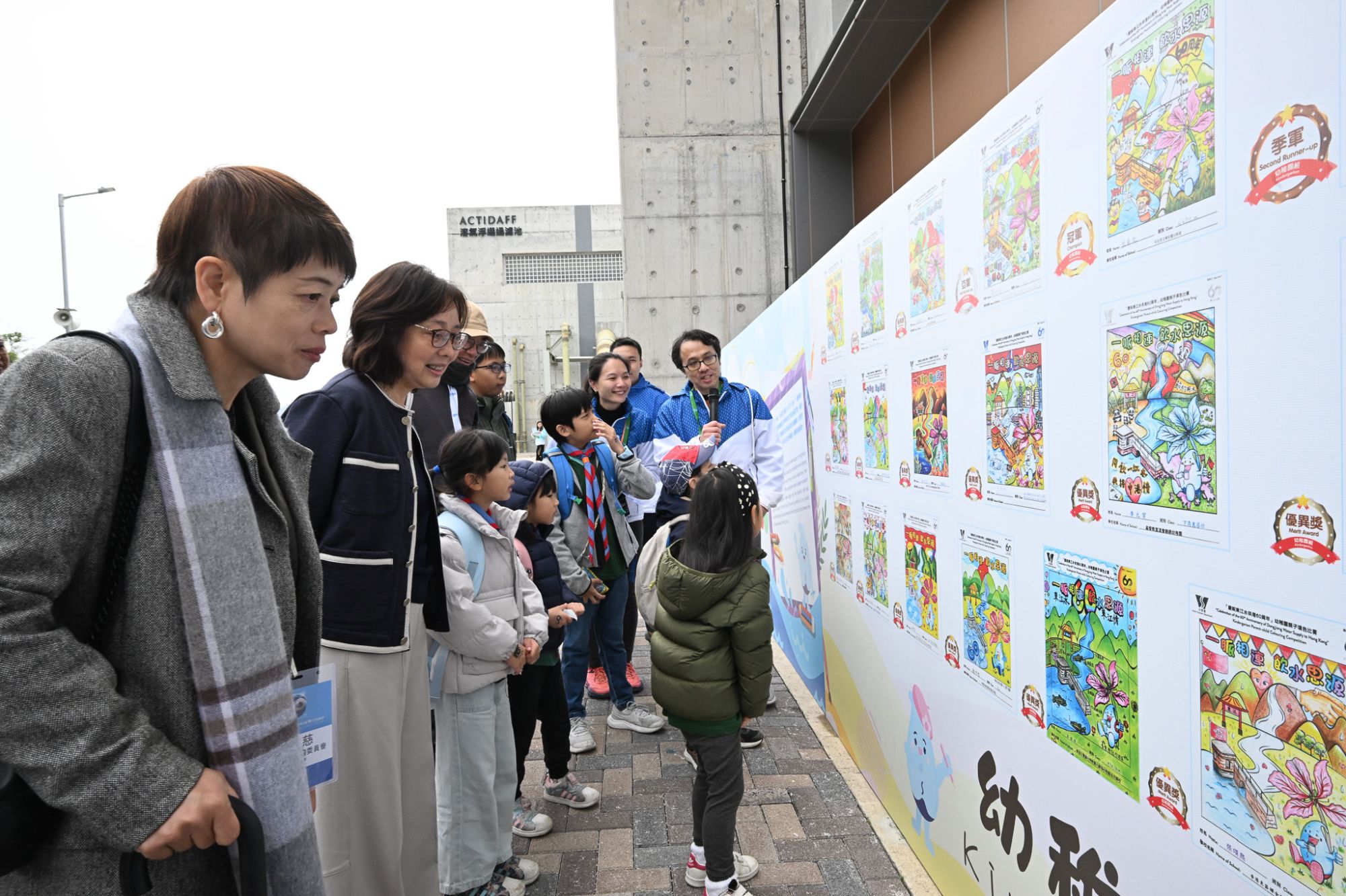 發展局局長甯漢豪（左二）於「東江水供港六十周年同樂日」參觀相關主題填色比賽的得獎作品。
