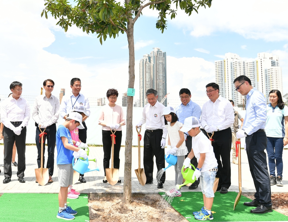 The day on which Kai San Road opened is also the Community Planting Day in the local area.  Chief Executive, Mrs Carrie LAM (back row, fourth left); Secretary for Development, Mr Michael WONG (back row, third left); Permanent Secretary for Development (Works), Ir HON Chi-keung (back row, fifth left); Director of Civil Engineering and Development, Mr LAM Sai-hung (back row, sixth left); Chairman of Wong Tai Sin District Council, Mr LI Tak-hong (back row, seventh left); and Chairman of Kowloon City District Council, Mr PUN Kwok-wah (back row, second left), officiate at the planting ceremony together with other guests and children.