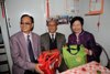 Mrs Lam presents a Lunar New Year gift to an elderly resident (centre) of St Peter's Village.