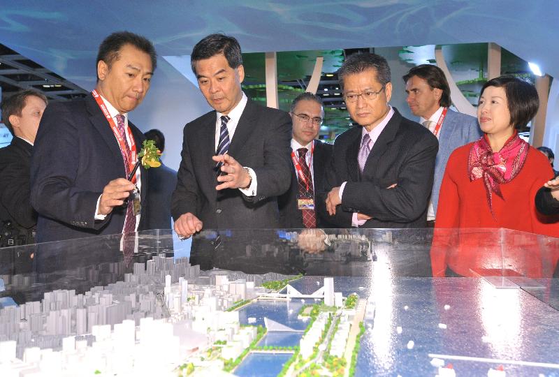Mr Leung (second left) and the Secretary for Development, Mr Paul Chan (second right), tour the Hong Kong Pavilion, which showcases the Government's major development initiatives. (Image)