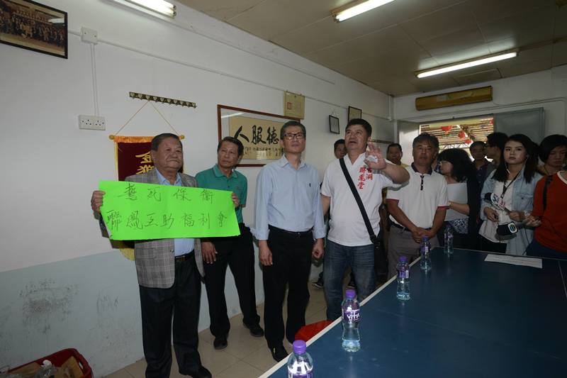 Mr Chan (third left) listens to the views of the representatives of a mutual aid association in Kwu Tung..