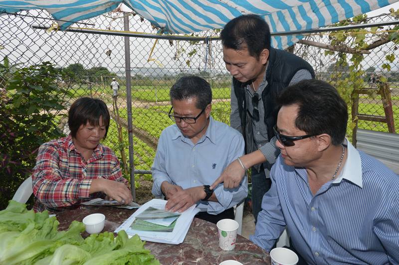 A farmer explains to Mr Chan (second left) the features of organic farming..