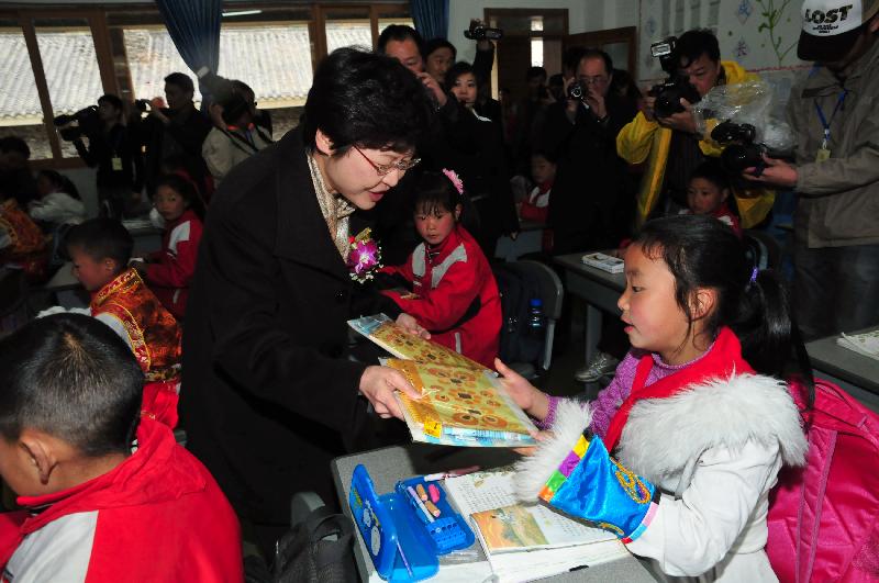 Mrs Lam distributes gifts of stationery to the students of Wolong Primary School.
