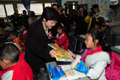 Mrs Lam distributes gifts of stationery to the students of Wolong Primary School.
