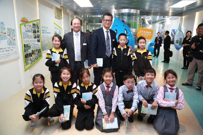 Mr Chan (back row, third left) and Mr Ma (back row, second left) are pictured with primary school students at the 'Water: Learn & Conserve' Resource Hall in the Water Resources Education Centre.