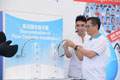 Mr Chan (first right) shows how to install a flow controller on a water tap.