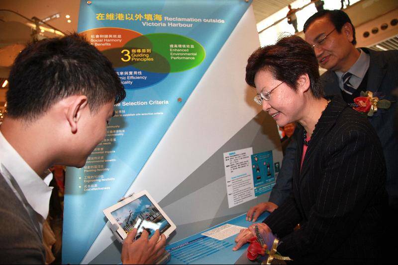 Mrs Lam tries the interactive games on reclamation and rock cavern development on a tablet PC at the launch ceremony of the Stage 1 Public Engagement on Enhancing Land Supply Strategy. (Image)