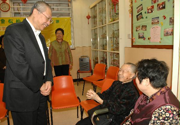 The Secretary for Housing, Planning and Lands, Mr Michael Suen, takes a photo with a group of elders at the Elderly Centre of Tsim Sha Tsui Kaifong Welfare Association.