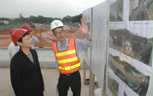 Staff of the Drainage Services Department briefs the Secretary for Development, Mrs Carrie Lam, today (September 10) on the flood prevention project in Kau Lung Hang.