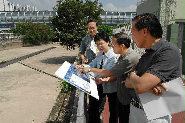 The Secretary for Development, Mrs Carrie Lam, today (September 29) is briefed by the Director of Drainage Services, Mr Wong Chee-keung (second from right), on the flood prevention operation of the Yuen Long Nullahs. Looking on is the Permanent Secretary for Development (Works), Mr Mak Chai-kwong (first from right).