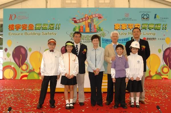 (From left) The Direct of Buildings, Mr Cheung Hau-wai; the Secretary for Development, Mrs Carrie Lam; the Chairman of the Hong Kong Housing Society, Mr Yeung Ka-sing; and the Chairman of the Urban Renewal Authority, Mr Barry Cheung Chun-yuen, together with the children performing at the ceremony.