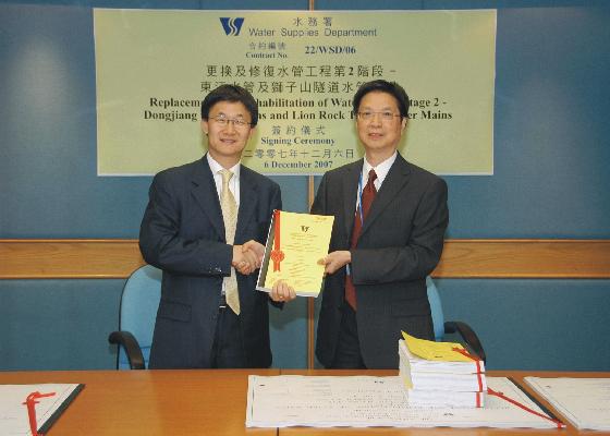 Mr Ng (right) shaking hands with the contractor, Director of Wo Hing Construction Co Ltd., Mr Tony Yue, after the signing ceremony.