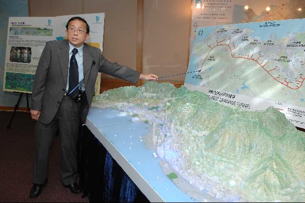 Mr Wong demonstrates through a model how the Hong Kong West drainage tunnel intercepts excessive rain water from the mid-levels and discharges it into the sea directly. The innovative method will solve the flooding problem.