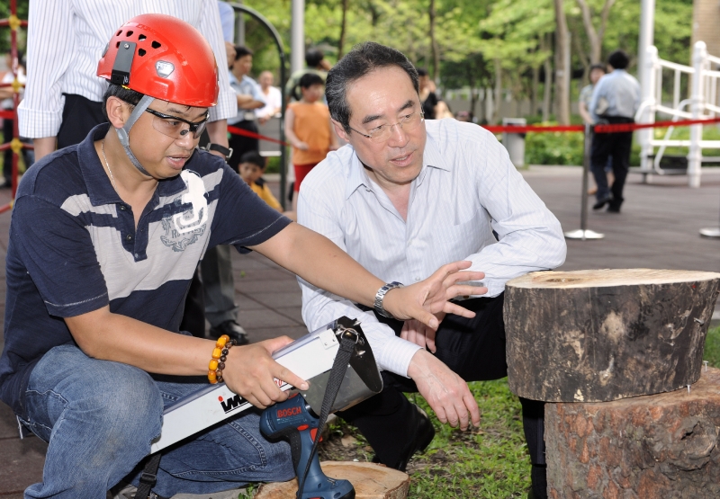Mr Tang watches tree examination by staff of the Leisure and Cultural Services Department at Victoria Park.