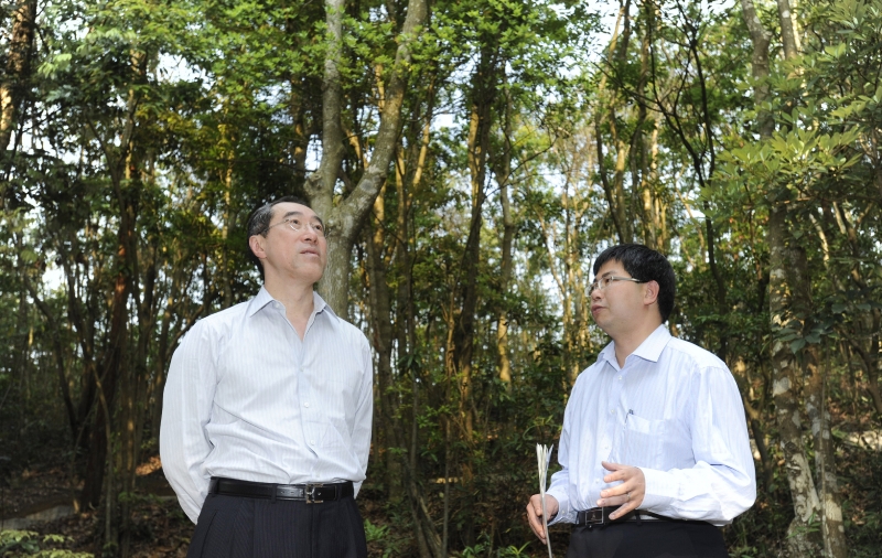 Mr Tang is briefed on vegetation management work in country parks by officers of the Agriculture, Fisheries and Conservation Department at Tai Tam Country Park.