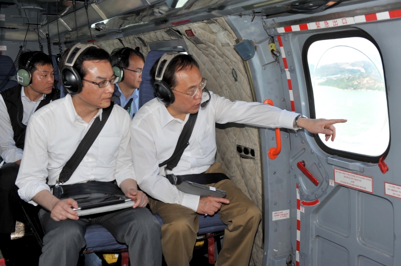 Mr Tsang (right), accompanied by the Permanent Secretary for Development (Works), Mr Wai Chi-sing, gets a bird's eye view of seven potential reclamation and two cavern sites across the territory.