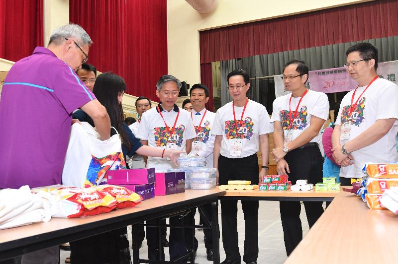 The Secretary for Development, Mr Eric Ma (third right), today (May 22) conducted
home visits in Kwai Tsing District under the "Celebrations for All" project.
Photo shows volunteers demonstrating the gift packing to officials participating
in home visits at the launch ceremony. 