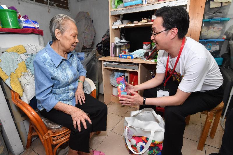 The Secretary for Development, Mr Eric Ma (right), today (May 22) visits an elderly person living in Lai King Estate to understand her living conditions and needs and distributes gift packs.