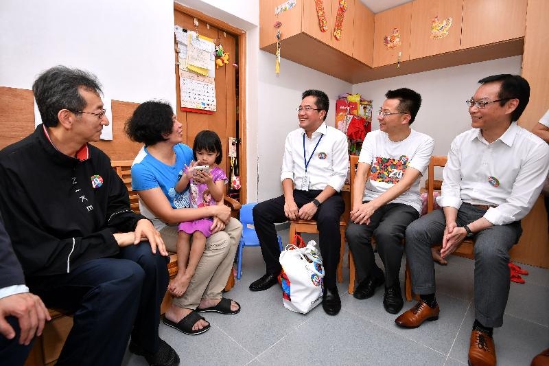 Accompanied by the Chairman of the Sham Shui Po District Council, Mr Ambrose Cheung (first left), the Secretary for Development, Mr Michael Wong (centre); the Director of Buildings, Mr Cheung Tin-cheung (second right); and the Managing Director of the Urban Renewal Authority, Mr Wai Chi-sing (first right), today (July 28) visit a family living in Un Chau Estate to learn more about their living conditions and needs.