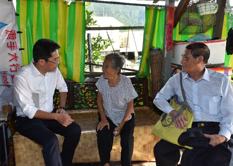 The Secretary for Development, Mr Michael Wong, visited Tai O this afternoon (August 24). Photo shows Mr Wong (left) visiting a resident at her stilted house to learn about about how they are affected by the flood and listening to their requests.