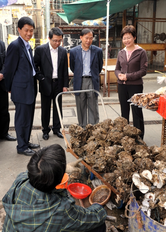 The Secretary for Development, Mrs Carrie Lam (right), chatting with an oyster stall operator in Lau Fau Shan.