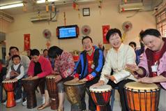 The Secretary for Development, Mrs Carrie Lam, joins the drumming performance by the mentally handicapped persons at the Jockey Club Rehabilitation Complex of Tung Wah Group of Hospitals.