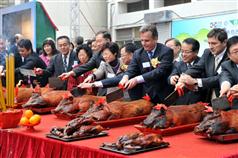 The Secretary for Development, Mrs Carrie Lam (centre), and other guests cut roast pork at the breakthrough ceremony for the Hong Kong West Drainage Tunnel today (February 17).