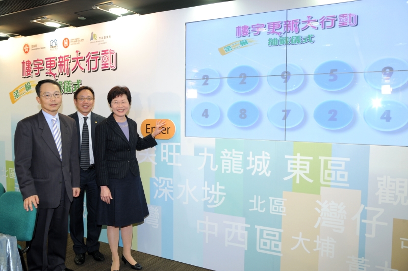 發展局局長林鄭月娥（右）與香港房屋協會行政總裁兼執行總幹事黃傑龍（中）及市區重建局行政總監羅義坤（左）啟動電腦抽籤儀式。