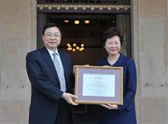 The Secretary for Development, Mrs Carrie Lam (right), presents a certificate of appreciation to the Secretary of Guangzhou University Committee of the Communist Party of China, Mr Yi Zuoyong (left).