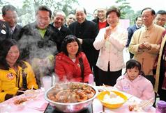 发展局局长林郑月娥在大埔林村与正在品嚐盆菜的的小朋友及其家人共庆新春。