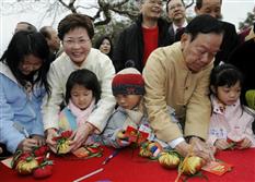 发展局局长林郑月娥在大埔林村仿真许愿树抛掷宝牒之前，与乡议局主席刘皇发和小朋友在祝愿宝牒上写上心愿。