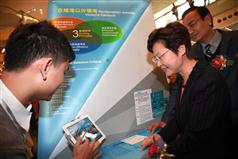 Mrs Lam tries the interactive games on reclamation and rock cavern development on a tablet PC at the launch ceremony of the Stage 1 Public Engagement on Enhancing Land Supply Strategy.