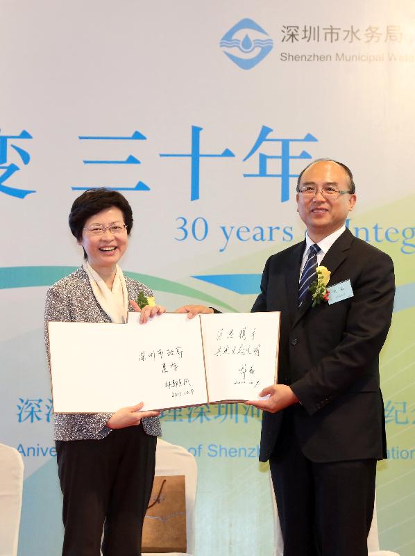 Mrs Lam (left) exchanges commemorative albums with the Mayor of Shenzhen, Mr Xu Qin.